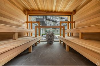 A long wooden bench with a round object in the middle of the room.